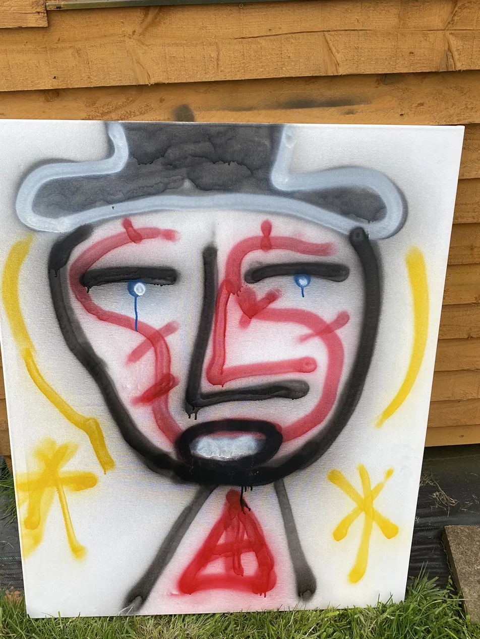 Spray paint portrait of a face wearing a grey hat, with red and black lines and blue tears